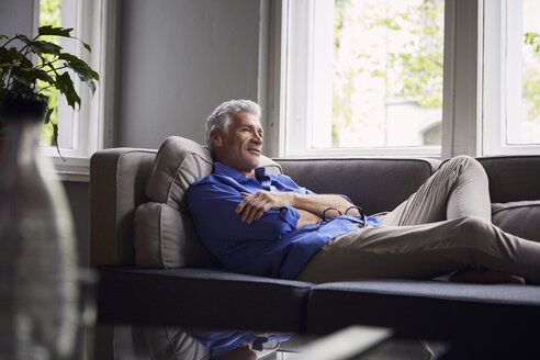 Pensive mature man lying on couch at home - RBF05949