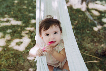 Porträt eines hungrigen kleinen Mädchens mit Löffel im Mund im Garten - GEMF01784