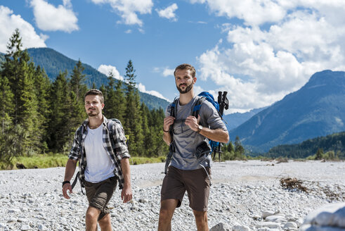 Germany, Bavaria, two hikers walking in dry creek bed - DIGF02783
