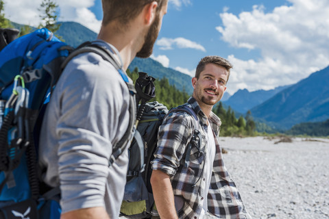 Germany, Bavaria, portrait of young hiker with backpack looking at his friend stock photo