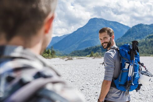 Germany, Bavaria, portrait of young hiker with backpack looking at his friend - DIGF02790