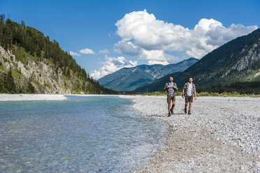 Germany, Bavaria, two hikers walking at riverside - DIGF02801