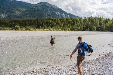 Deutschland, Bayern, zwei Wanderer mit Rucksäcken überqueren die Isar - DIGF02805