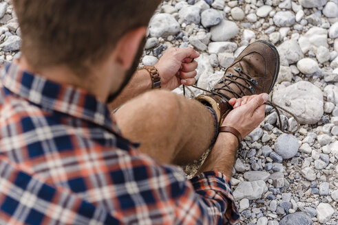 Hiker tying his shoe - DIGF02806