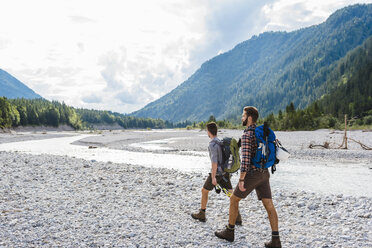 Germany, Bavaria, two hikers walking in dry creek bed - DIGF02812