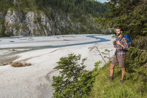 Germany, Bavaria, young hiker with backpack looking at distance stock photo