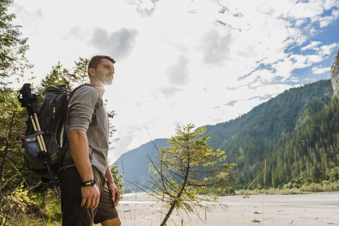 Germany, Bavaria, young hiker with backpack looking at distance - DIGF02815