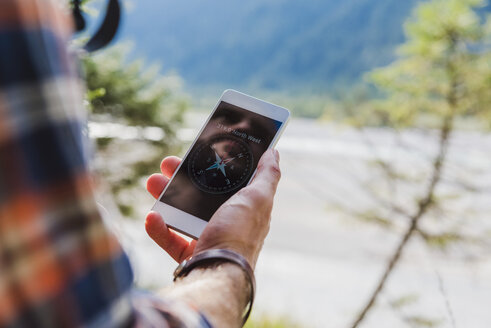 Hiker orientating with cell phone, close-up - DIGF02818