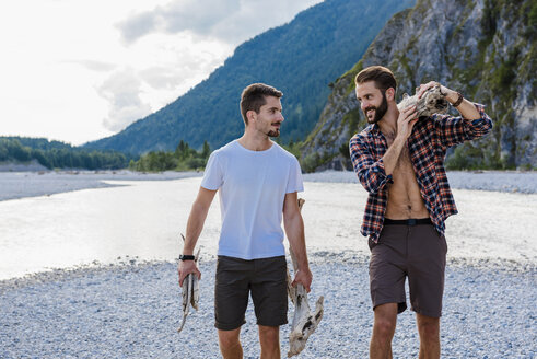 Germany, Bavaria, two friends collecting firewood in nature - DIGF02826