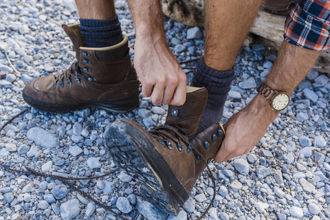 Wanderer beim Anziehen seiner Schuhe, Teilansicht, lizenzfreies Stockfoto