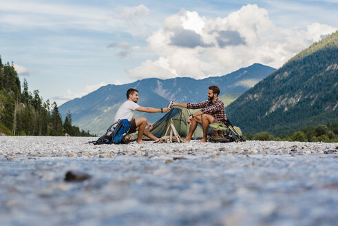 Germany, Bavaria, two hikers camping on gravel bank - DIGF02834