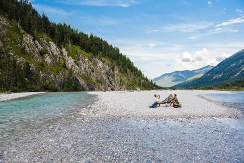 Germany, Bavaria, two hikers camping on gravel bank - DIGF02835