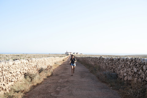 Spanien, Menorca, Einzelreisender auf leerer Straße, lizenzfreies Stockfoto