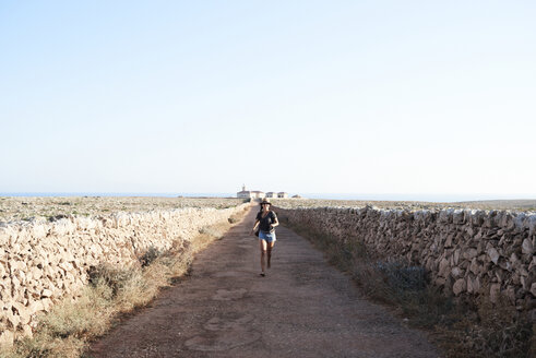 Spanien, Menorca, Einzelreisender auf leerer Straße - IGGF00148