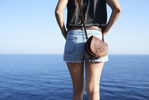 Rückenansicht einer Frau mit Blick auf das Meer, Teilansicht - IGGF00154