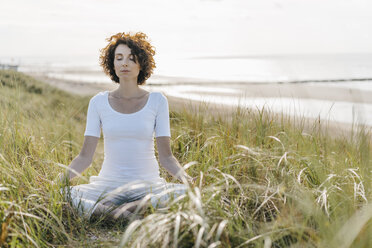 Frau übt Yoga in der Stranddüne - KNSF02548