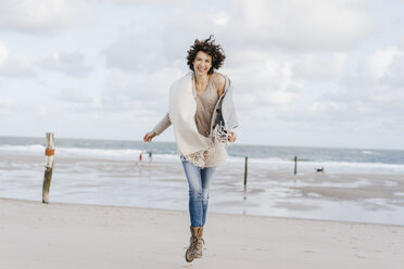 Glückliche Frau beim Laufen am Strand - KNSF02556