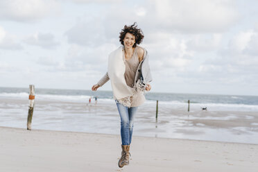 Happy woman running on the beach - KNSF02556