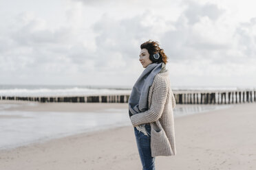 Frau mit Kopfhörern am Strand stehend - KNSF02558