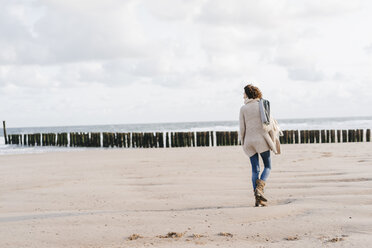 Frau geht am Strand spazieren - KNSF02568