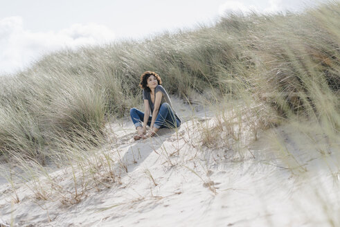 Frau sitzt in Stranddüne - KNSF02591