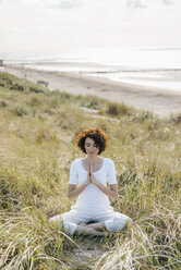 Frau übt Yoga in der Stranddüne - KNSF02615