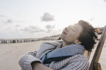 Woman relaxing in deckchair on the beach - KNSF02636