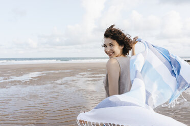 Glückliche Frau mit Tuch am Strand - KNSF02641