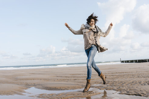 Happy woman running on the beach - KNSF02643