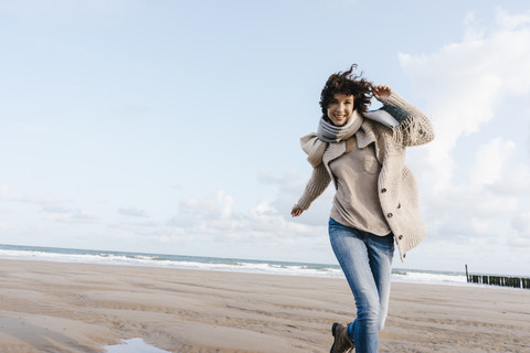 Glückliche Frau beim Laufen am Strand, lizenzfreies Stockfoto