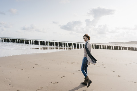 Woman walking on the beach stock photo