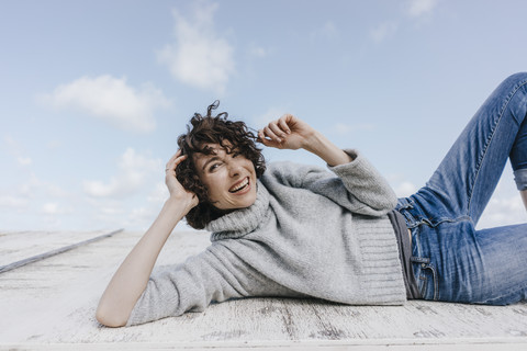 Glückliche Frau auf Holzkiste liegend, lizenzfreies Stockfoto