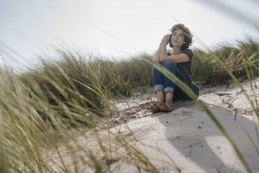 Woman sitting in beach dune - KNSF02672
