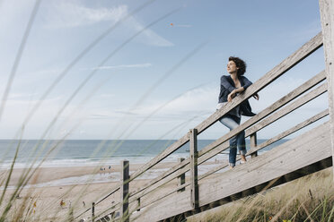 Frau steht auf der Strandpromenade am Strand - KNSF02684