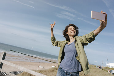 Glückliche Frau am Strand, die ein Selfie macht - KNSF02689