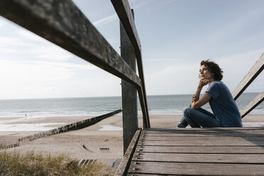 Woman sitting on boardwalk at the beach - KNSF02690