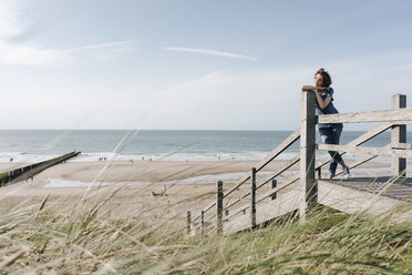 Frau steht auf der Strandpromenade am Strand - KNSF02691