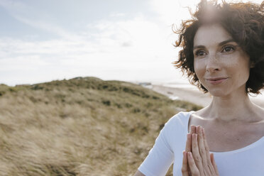 Woman with folded hands in beach dune - KNSF02692