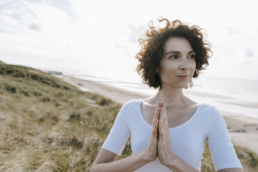 Woman with folded hands in beach dune - KNSF02693