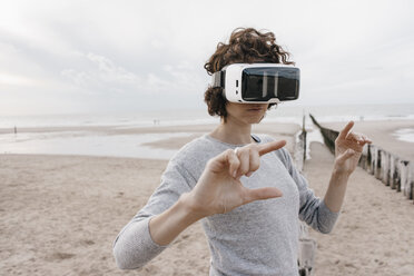 Frau am Strand mit VR-Brille - KNSF02702