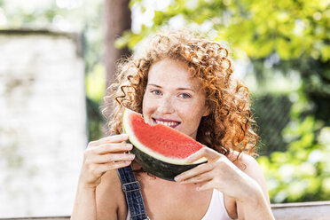 Portrait of redheaded young woman with watermelon - FMKF04423