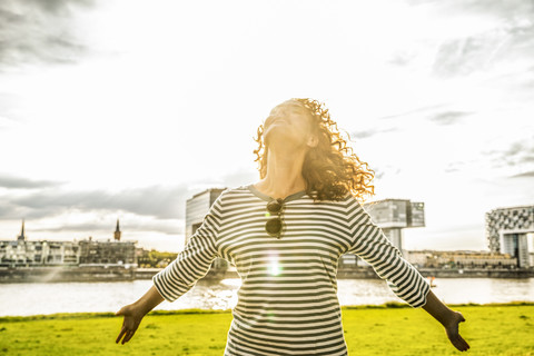 Deutschland, Köln, junge Frau genießt das Sonnenlicht, lizenzfreies Stockfoto