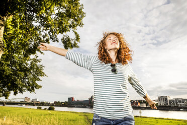 Deutschland, Köln, junge Frau genießt das Sonnenlicht - FMKF04439