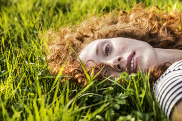 Portrait of redheaded young woman lying on meadow - FMKF04461