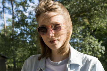 Portrait of a young woman in nature, wearing sunglasses - LMF00744