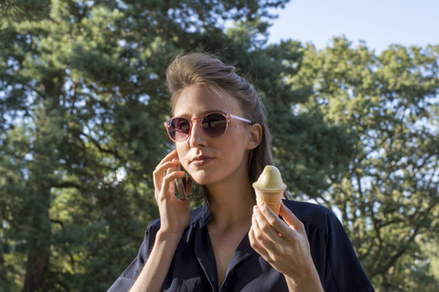 Junge Frau mit Eiswaffel und Smartphone, lizenzfreies Stockfoto
