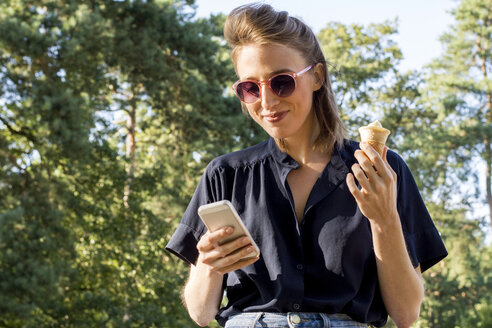 Junge Frau mit Eiswaffel und Smartphone - LMF00751