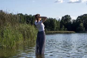 Junge Frau genießt die Sonne an einem See - LMF00763