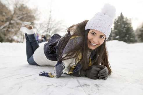 Frau mit Schlittschuhen auf Schnee liegend - HAPF02119