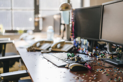 Desk with confetti and streamers on computer after a birthday party - KNSF02725